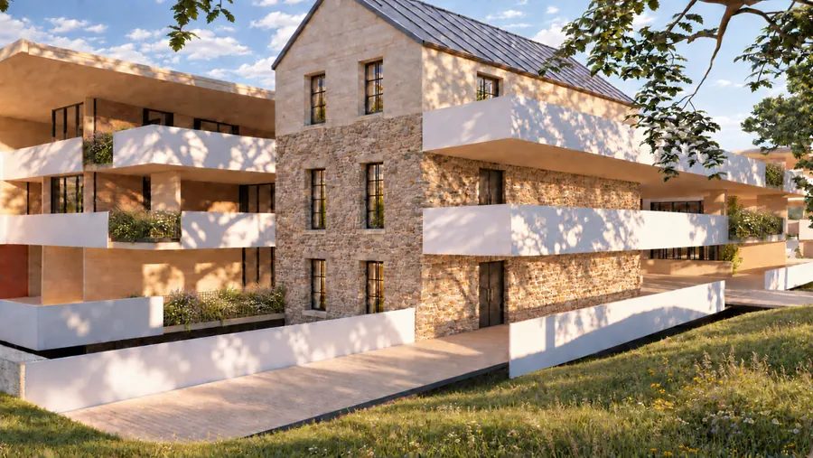 Der Bestandsbau aus Bruchstein mit steilem Giebel und Metalldach, links und rechts die neuen Wohnebenen mit weißen Brüstungsbändern und bepflanzten Trögen; davor ein gepflasterter Weg und die Wiese, auf der Fassade die Schatten eines Baums.